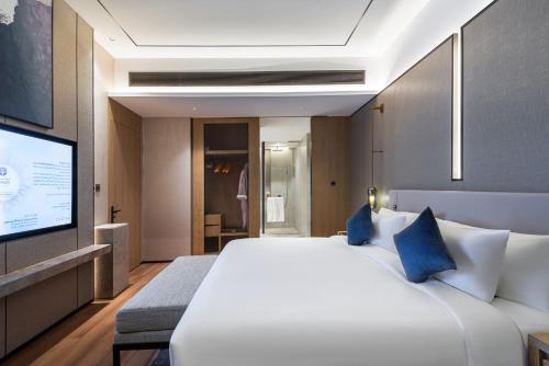 a bedroom with a large white bed and a flat screen tv at Braira Abha Hotel فندق بريرا أبها in Abha