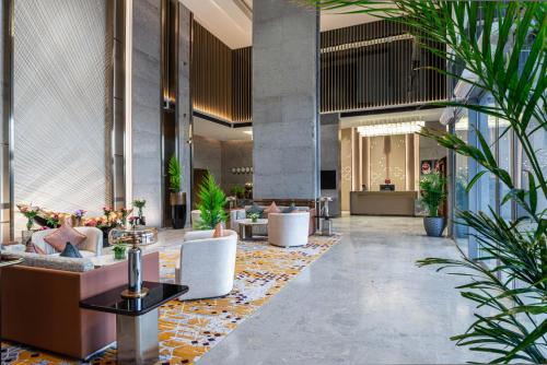a lobby with chairs and tables and plants at Braira Abha Hotel فندق بريرا أبها in Abha