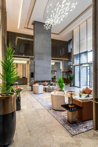 a lobby with couches and plants in a building at Braira Abha Hotel فندق بريرا أبها in Abha