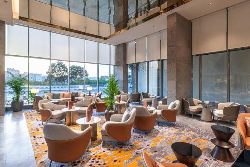 a lobby with chairs and tables and large windows at Braira Abha Hotel فندق بريرا أبها in Abha