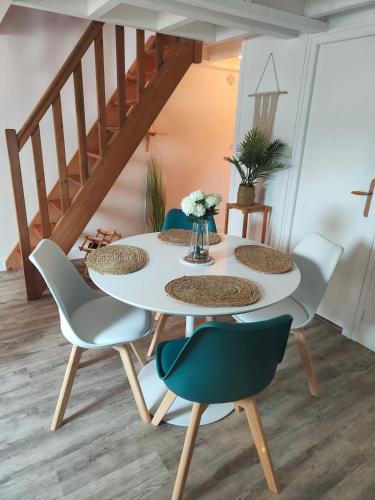 a table and chairs in a room with a staircase at Le p'tit Palais in Le Palais