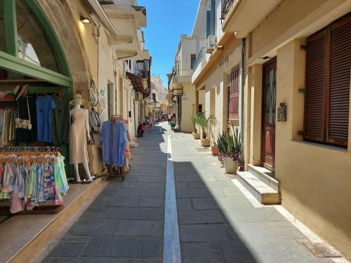 an alley in an old town with clothes shops at Old town - Fortezza Nest in Rethymno Town