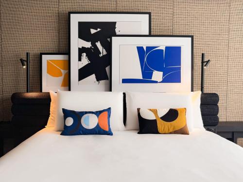 a bedroom with a white bed with framed pictures at Mercure Dijon Centre Clemenceau in Dijon