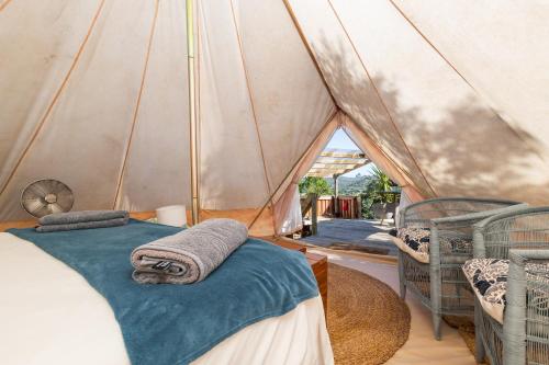 a bedroom with a tent with two beds and towels at Zen Valley Glamping in Plettenberg Bay