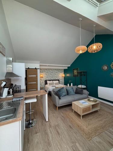 une cuisine et un salon avec un canapé dans l'établissement Le 89 Appartement au calme au centre de Cherbourg, à Cherbourg en Cotentin