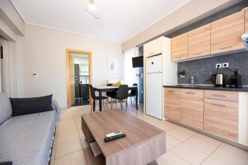 a living room with a couch and a table and a kitchen at DreamCoast Apartments I in Artemida