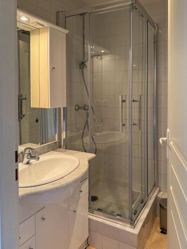 une salle de bain avec un lavabo et une douche en verre dans l'établissement Les Papillons T2 Le Moulleau Arcachon plage à 50m, à Arcachon