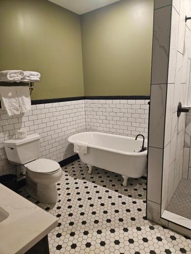 a bathroom with a tub and a toilet and a sink at Albany Merchants Hotel in Albany