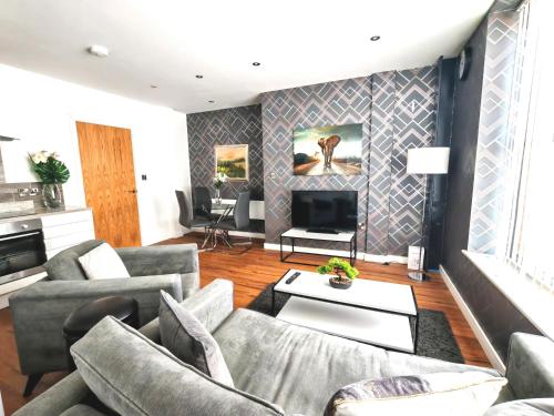 a living room with couches and a tv at The Cosy Quarters - Popworks in Manchester