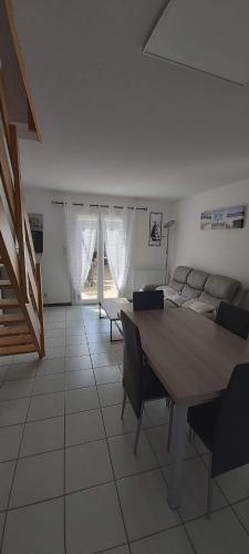 un salon avec une table et un canapé dans l'établissement Maison des dunes, à 100m de la mer, à Saint-Hilaire-de-Riez