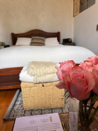 a bedroom with a bed and a vase with roses at Skema Collections Quito in Quito