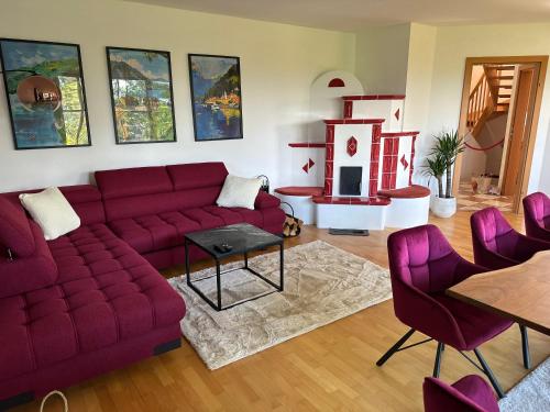 a living room with a red couch and a table at Villa Sara - Wörtherseeblick, Sauna, Panoramaterrasse in Sankt Bartlmä