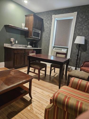 a living room with a table and a kitchen at Albany Merchants Hotel in Albany