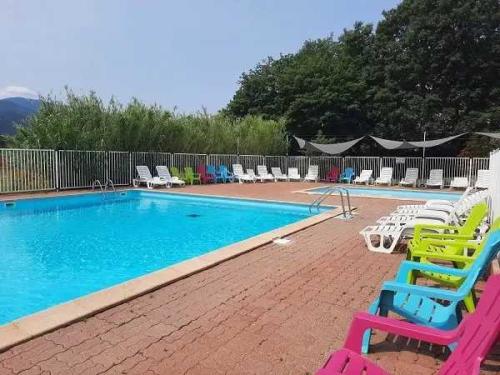 - une piscine avec des chaises colorées dans l'établissement Cabane 3 étoiles - cca0gbc, à Saint-Jean-Pla-de-Corts