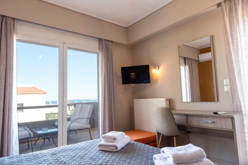 a hotel room with a bed and a large window at DreamCoast Apartments I in Artemida