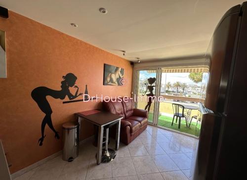 un salon avec un autocollant de sirène sur le mur dans l'établissement Village naturiste port nature 618, au Cap d'Agde