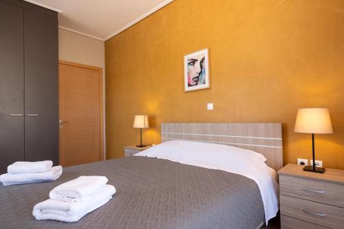 a bedroom with a bed with towels on it at DreamCoast Apartments I in Artemida