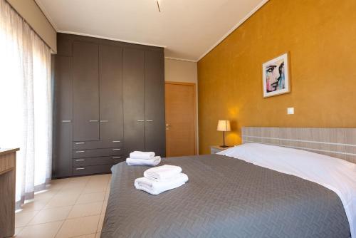 a bedroom with a bed with towels on it at DreamCoast Apartments I in Artemida