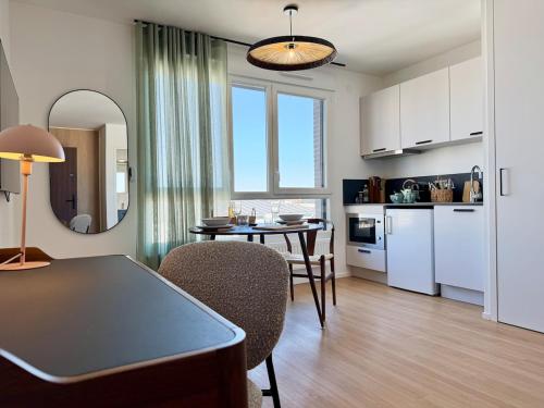 un salon avec une table et une cuisine dans l'établissement We Live Inn Sharies Reims - A605, à Reims