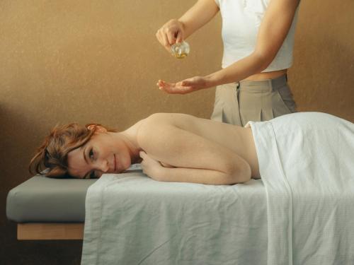 a woman laying on a bed getting a massage at Fuxbau in Stuben am Arlberg