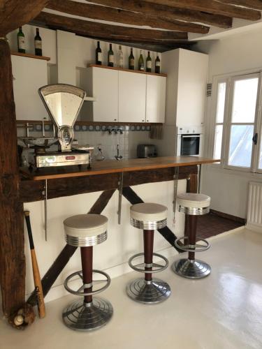 une cuisine avec un comptoir et des tabourets dans une pièce dans l'établissement 8 Place du Tertre, à Paris