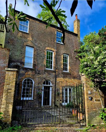 an old brick house with a gate in front of it at Coach House Greenwich in London