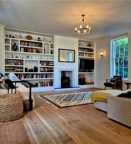 a living room with a fireplace and bookshelves at Coach House Greenwich in London