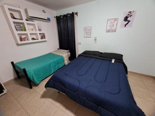 a bedroom with a blue bed and a green pillow at La Casa de Los Mellis.. in La Banda