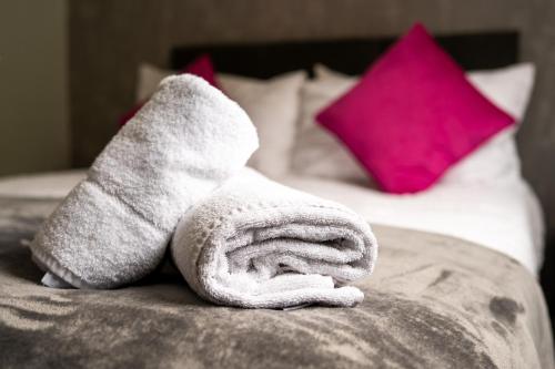 a towel sitting on top of a bed at Hinckley Flats in Hinckley