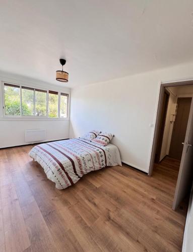 une chambre blanche avec un lit et une fenêtre dans l'établissement Les Jonquilles, à Marseille