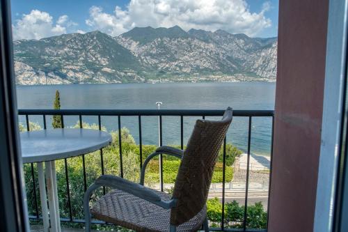 a balcony with a table and a view of the water at Villa Andreis in Malcesine