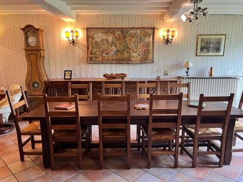 a dining room with a large wooden table and chairs at Le Gîte d'antan - L'Artdu'Net - in Omicourt