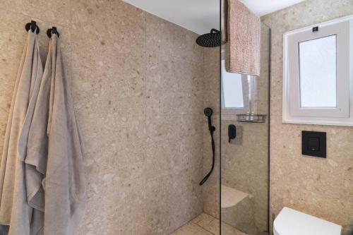 a bathroom with a shower with a glass door at Villa Astrofegia Moonlit Escape with Sea Views in Pachyammos
