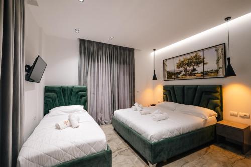 two beds in a hotel room with towels on them at Hotel Eagle in Ksamil