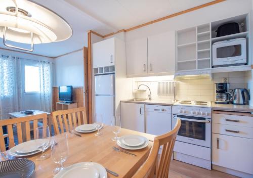 a kitchen with a wooden table with chairs and a dining room at Stöten Mitt Lägenheter in Sälen
