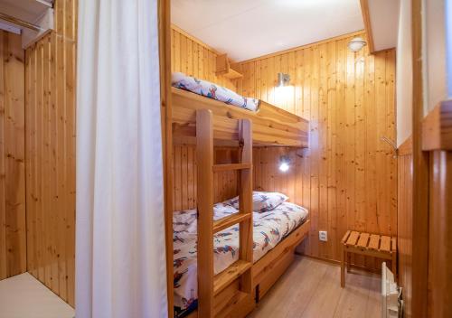 a bunk bed in a room with wooden walls at Stöten Mitt Lägenheter in Sälen