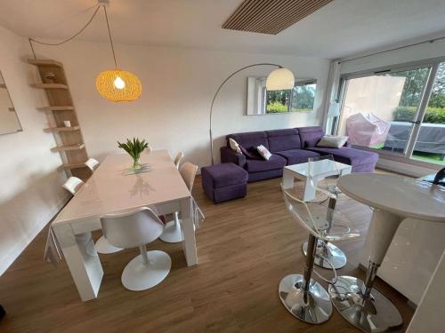 - un salon avec une table et un canapé violet dans l'établissement Appartement moderne, 2 chambres, terrasse vue mer,, à La Seyne-sur-Mer