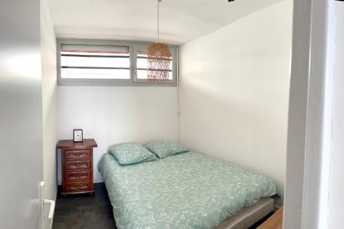 une petite chambre avec un lit et une fenêtre dans l'établissement Évasion paisible au Ponant, entre pins & étang , plage a pied, à La Grande Motte