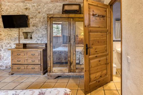 Un dormitorio con una cama y una puerta de madera. en Can Casadellà, en Serra de Daró