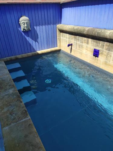 une piscine en face d'un bâtiment bleu dans l'établissement chambre sur terrasse, à Bergerac