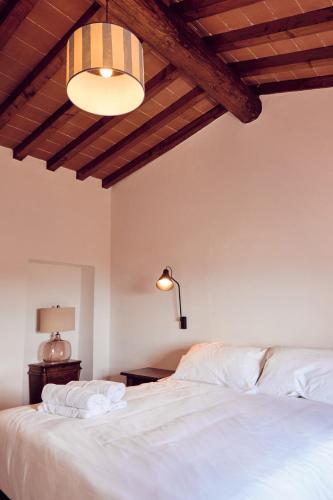 a bedroom with a large white bed and a lamp at Agriturismo Fattoria Poggio di Fiesole in Fiesole