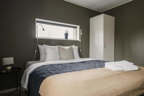 a bedroom with a large bed with a window at Guestly Homes - Stylish 3BR Stay in Peaceful Surroundings in Piteå