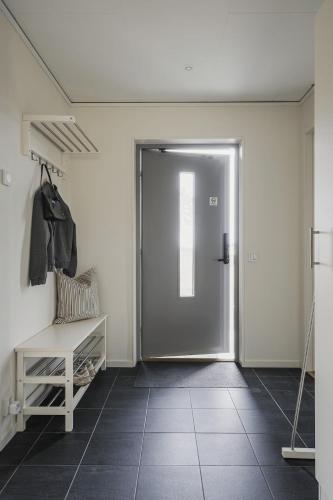 a hallway with a door and a bench in a room at Guestly Homes - Stylish 3BR Stay in Peaceful Surroundings in Piteå