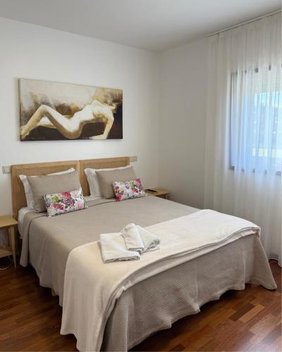a bedroom with a bed with two towels on it at Guest House MJ in Póvoa de Varzim