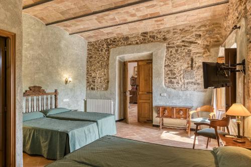 Un dormitorio con una cama y un televisor en una habitación. en Can Casadellà, en Serra de Daró