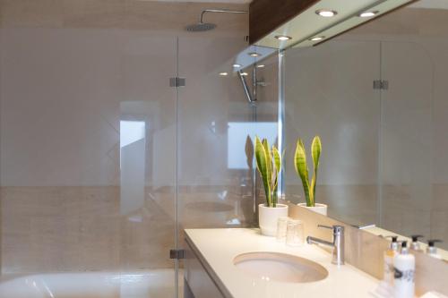 a bathroom with a sink and a shower and a mirror at Pousada Geres-Caniçada in Geres