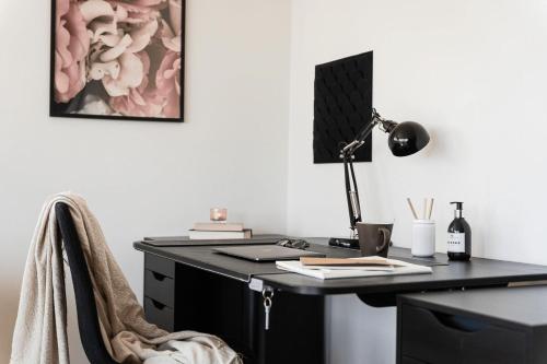 an office with a black desk with a lamp at Guestly Homes - Stylish 3BR Stay in Peaceful Surroundings in Piteå