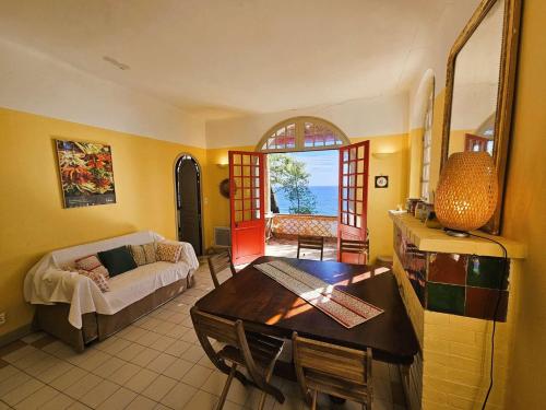 un salon avec une table et un canapé dans l'établissement Maison de plain-pied avec vue mer, à Saint-Mandrier-sur-Mer