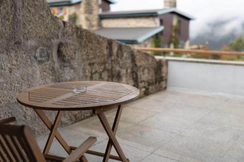 a small wooden table sitting on a balcony at Pousada Geres-Caniçada in Geres