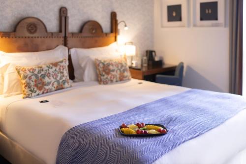 a bed with a plate of fruit on it at Pousada Geres-Caniçada in Geres